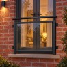 Balcon à la française vitré, sur une façade en brique au crépuscule