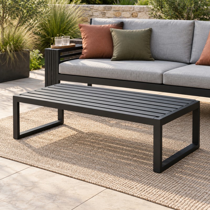Garten-Couchtisch aus Stahl, vor einem Gartensofa mit Polstern auf einer Steinterrasse