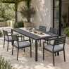 Mesa de comedor de jardín de acero, puesta para comer con seis sillas en una terraza de piedra