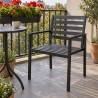 Sedia da giardino in acciaio con braccioli, su un balcone con il caffè del mattino
