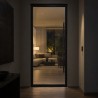 Steel and Glass Pivot Loft Door, closed at night with the room lit behind the glass