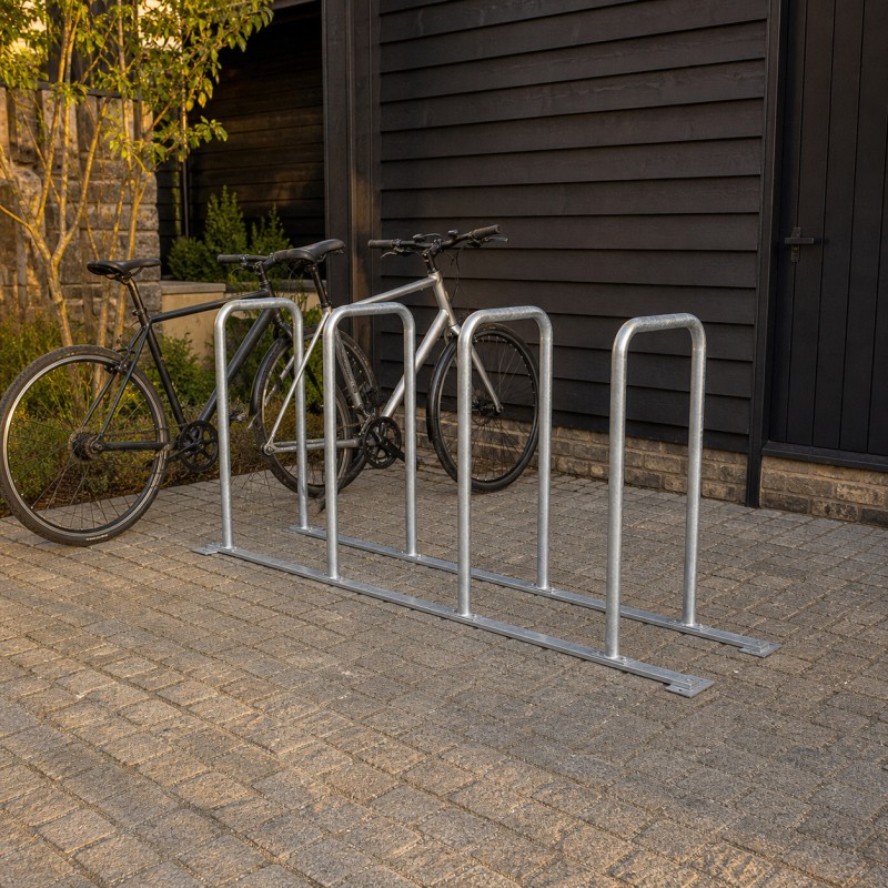 Aparcabicicletas de Acero Soldado, con una bicicleta junto a un edificio revestido de madera