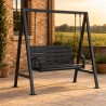 Dondolo da Giardino a Panca, su un patio in pietra accanto a una casa in mattoni al tramonto