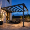 Pérgola de acero con vigas vistas, sobre un salón exterior al anochecer